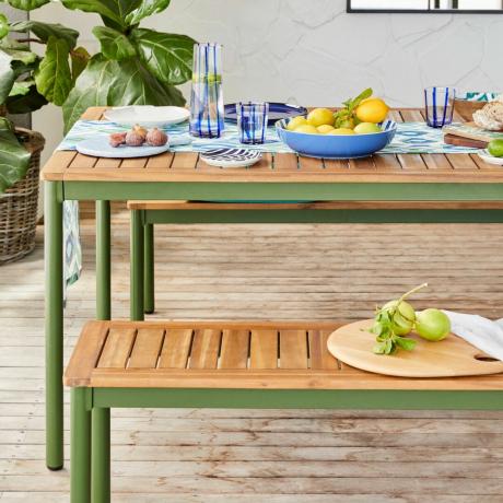 Drveni i zeleni blagovaonski stol, plavi set posuđa, limun, sobna biljka