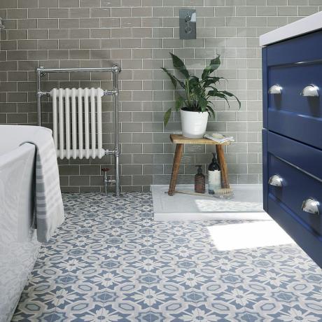 Badeværelse med blå enheder og blåt og hvidt mønstret gulv