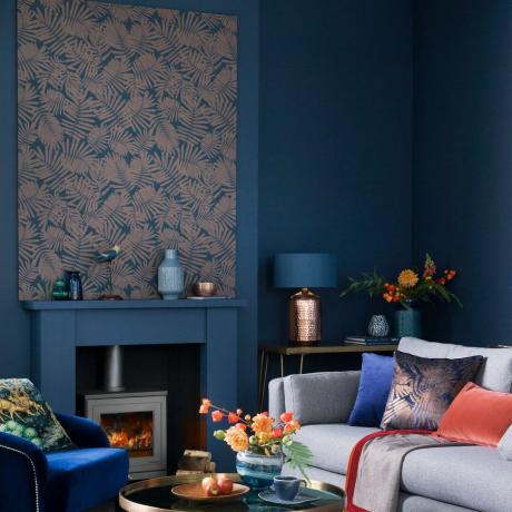 Blau gestrichenes Wohnzimmer mit tapezierter Platte über dem Kamin