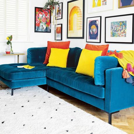niebieska sofa i jasny dywanik w salonie
