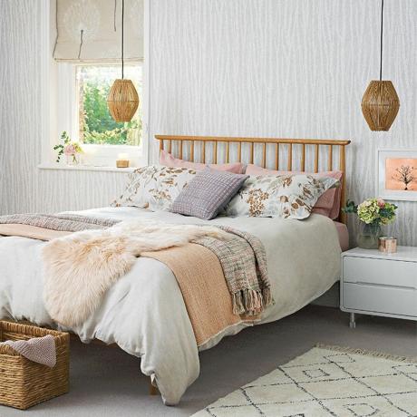 Dormitor alb cu pat din lemn și cuverturi tricotate și blană