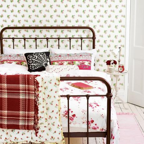 Dormitor cu pat din fier forjat si tapet floral