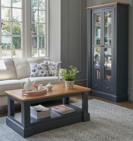 sala de estar azul con sofá crema y muebles pintados de azul con tapas de madera rústica