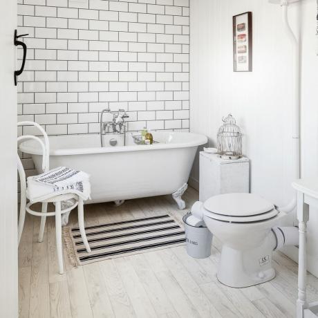 Baltas vonios kambarys su dažytomis grindimis ir balta šviesa