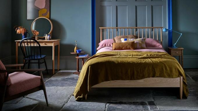 Ciemna sypialnia z drewnianą ramą łóżka Ercol i toaletką