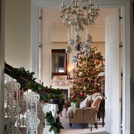 크리스마스로 장식된 전통적인 복도에서 나무가 있는 거실까지의 전망
