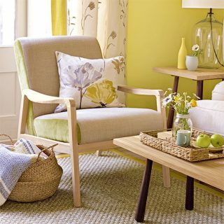Gele woonkamer met mooie bloemenprints en fauteuil