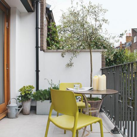 nápad s balkónom a záhradou so stolom a stoličkami v bistre a črepníkovým olivovníkom