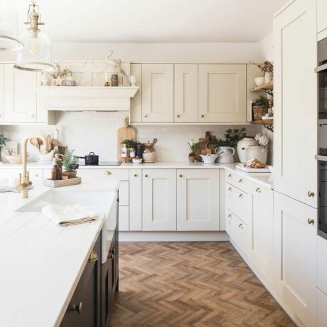 Virtuvės kampas su beveik baltu pagrindu ir sienomis bei medinėmis atviromis lentynomis