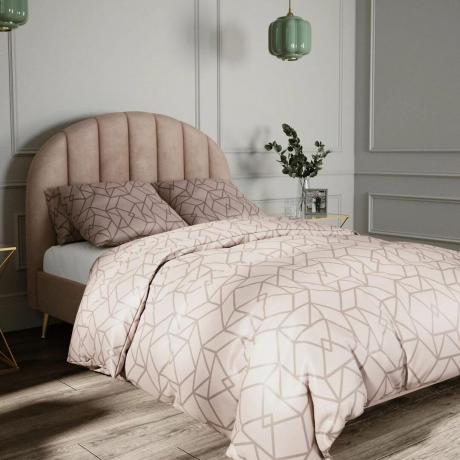 Rosa sängram med rosa sängkläder i ett sovrum
