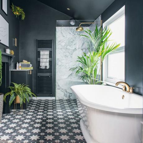 Mörkmålat badrum med badkar och mönstrat golv