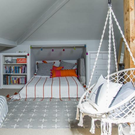 podkrovní dětská ložnice s postelí zabudovanou do okapu a závěsnou židlí