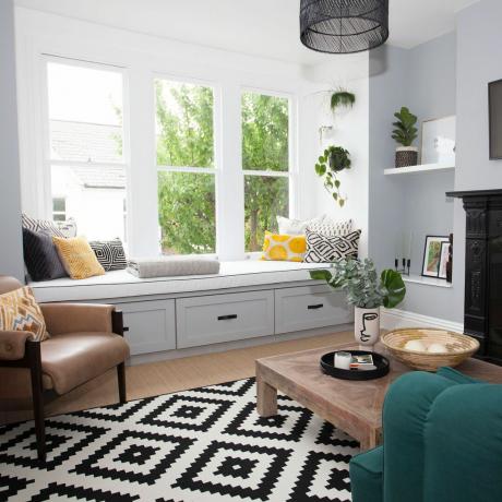 Obývací pokoj se sedadlem u okna a monochromatickým geometrickým kobercem