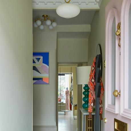 Hol cu ​​o ușă deschisă în față roz, tavan înalt și podea cu model de romb