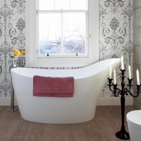 Fürdőszoba monokróm damaszt tapétával a papucsfürdő mögött