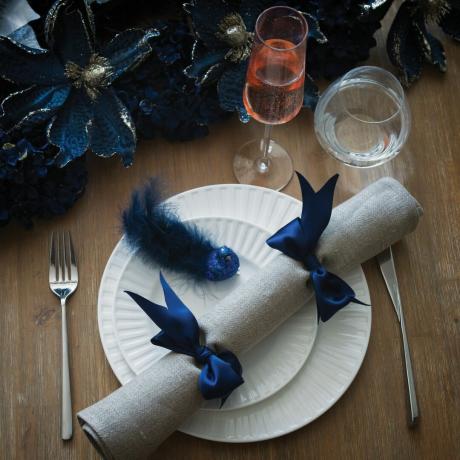 Linne servett cracker på vita tallrikar med blå jultema