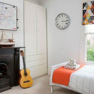 Barnets vita sovrum med orange accenter
