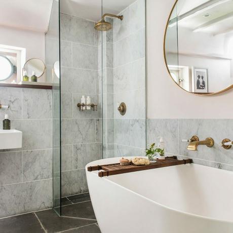ljusrosa badrum med grå marmorplattor och öppet duschkabin i glas