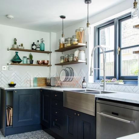 monokromt køkken med sorte skabe, hvide klinker og rustfri vask