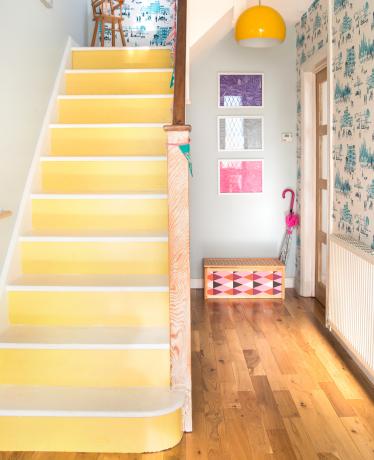 Escaliers peints en jaune dans le couloir avec papier peint imprimé bleu