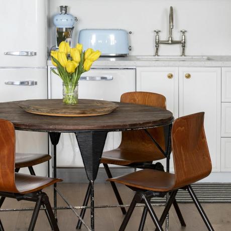 кухињска трпезарија са округлим дрвеним столом и трпезаријским столицама