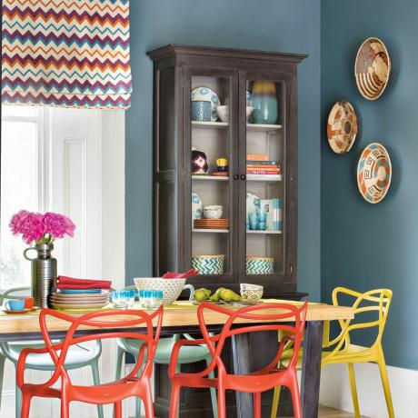 Blå matsal med byrå med glasfront och mönstrade persienner