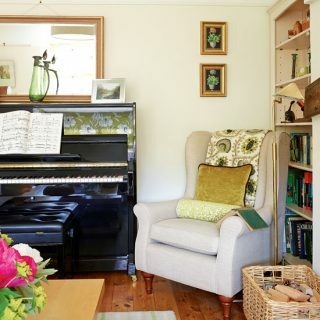 Mysigt vardagsrum med traditionell bevingad fåtölj och upprätt piano