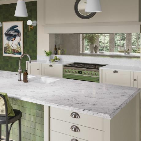 Vihreä keittiö, jossa marmoritasot ja peilattu backsplash.