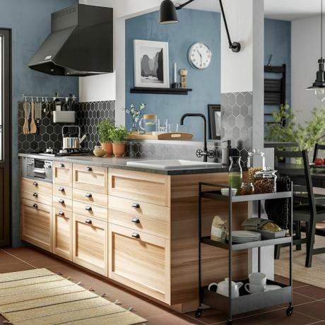Černý úložný vozík v dřevěné designové kuchyni