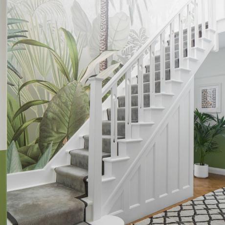 Botānisks sienas gleznojums uz baltām kāpnēm ar pelēku skrējēju