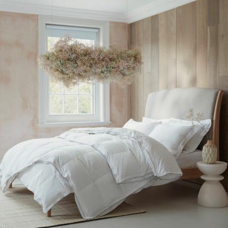 Dormitorio con cama cubierta con edredón