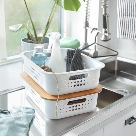 Két egymásra rakható kosár tisztítószerekkel a mosogató mellett