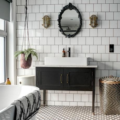 Jednobarevná úprava koupelny s modrou stěnou a černým rámem sprchy