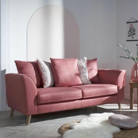 Rožinė sofa, išbarstyta rožinėmis ir pilkomis pagalvėlėmis