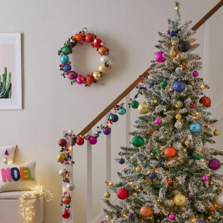 Uma árvore de Natal coloridamente decorada na parte inferior de uma escada