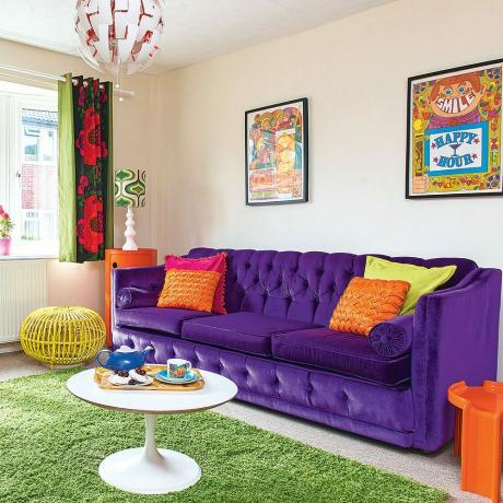 Fargerik moderne stue med lilla sofa og grønt teppe