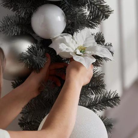 Крупни план божићног венца са белом божићном звездом међу белим и сребрним куглицама