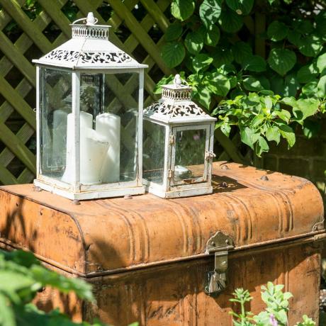 Lanterne de grădină din metal alb ruginit deasupra trunchiului de metal ruginit
