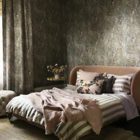 سرير مزدوج في غرفة مغطاة بورق الجدران