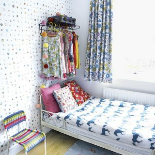 Modernt sovrum med mönstrad tapet och motivlinne