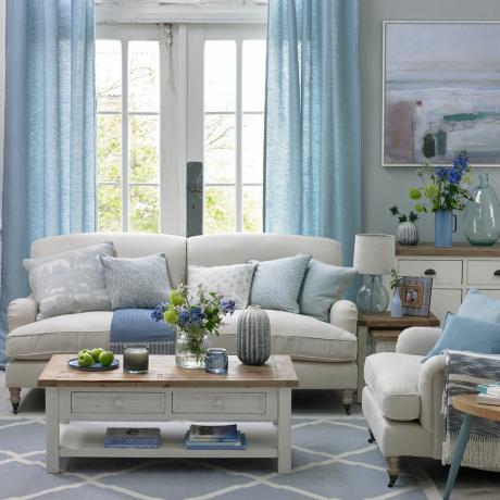 pīles olu zilā viesistaba ar baltu dīvānu un baltu koka kafijas galdiņu
