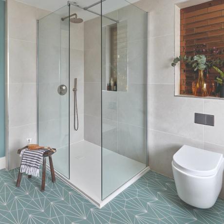 Kúpeľňa so sprchovacím kútom a WC a vzorovaná podlaha