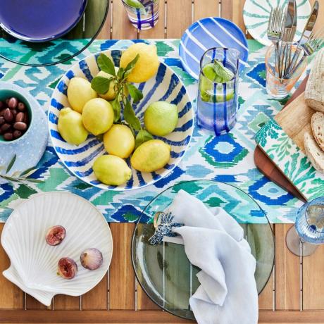 Zestaw zastawy stołowej inspirowany morzem, serwujący cytryny i owoce na drewnianym blacie