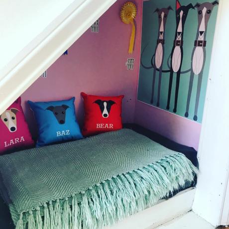під сходами спальня для собак з рожевими стінами та персоналізованими подушками