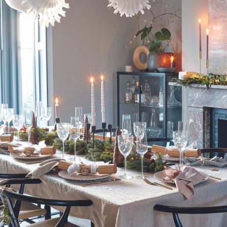 Sala de jantar com mesa de Natal em cores neutras.