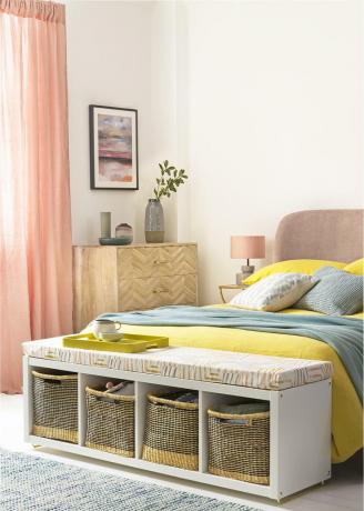 dormitorio blanco con cortinas de melocotón, cama de color rosa ruborizado y unidad de almacenamiento al pie del extremo