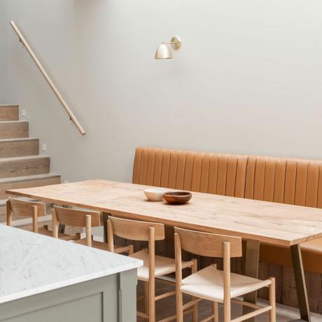 avatud planeeringuga köök-söögituba koos nahast banketi istumisnurga ja köögisaare, katuseakna ja seinavalgustitega