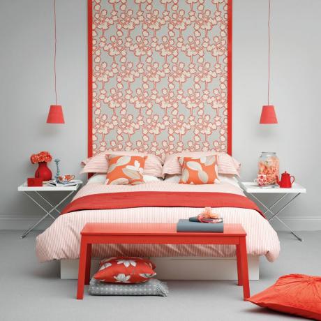 חדר שינה עם קיר בצבע אדום מאחורי המיטה