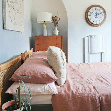 Spalnica z rožnato posteljnino in učinkom ombre barve na stenah