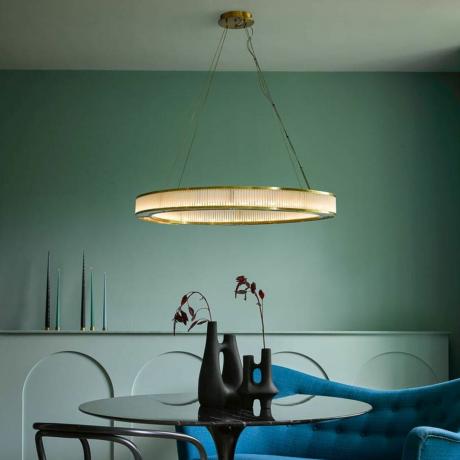 Comedor verde grisáceo con una exclusiva lámpara de araña dorada